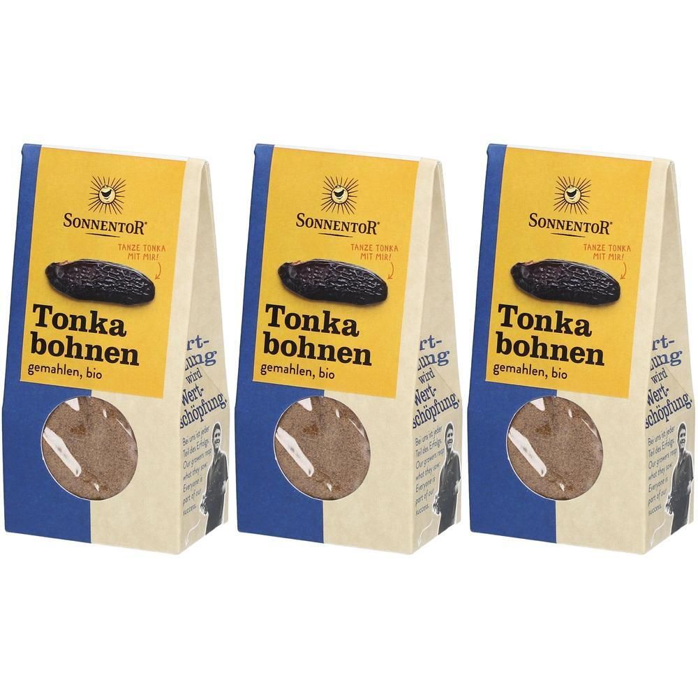 Drei Beutel mit gemahlenen Tonkabohnen. Gelbes Etikett mit Logo und Schriftzug. Blaue und beige Verpackung.
