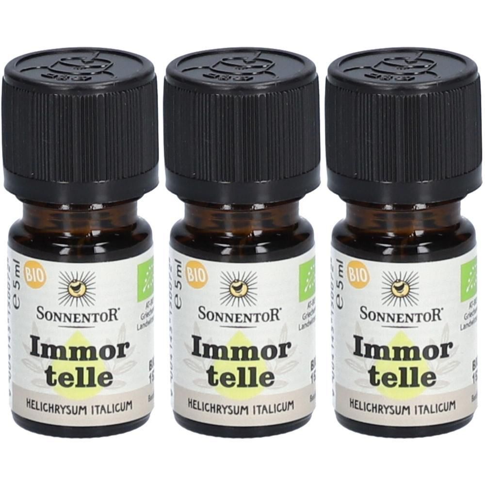 Drei kleine braune Glasflaschen mit schwarzen Deckeln. Auf den Etiketten steht "Sonnentor Immortelle". Bio-Zertifizierung.