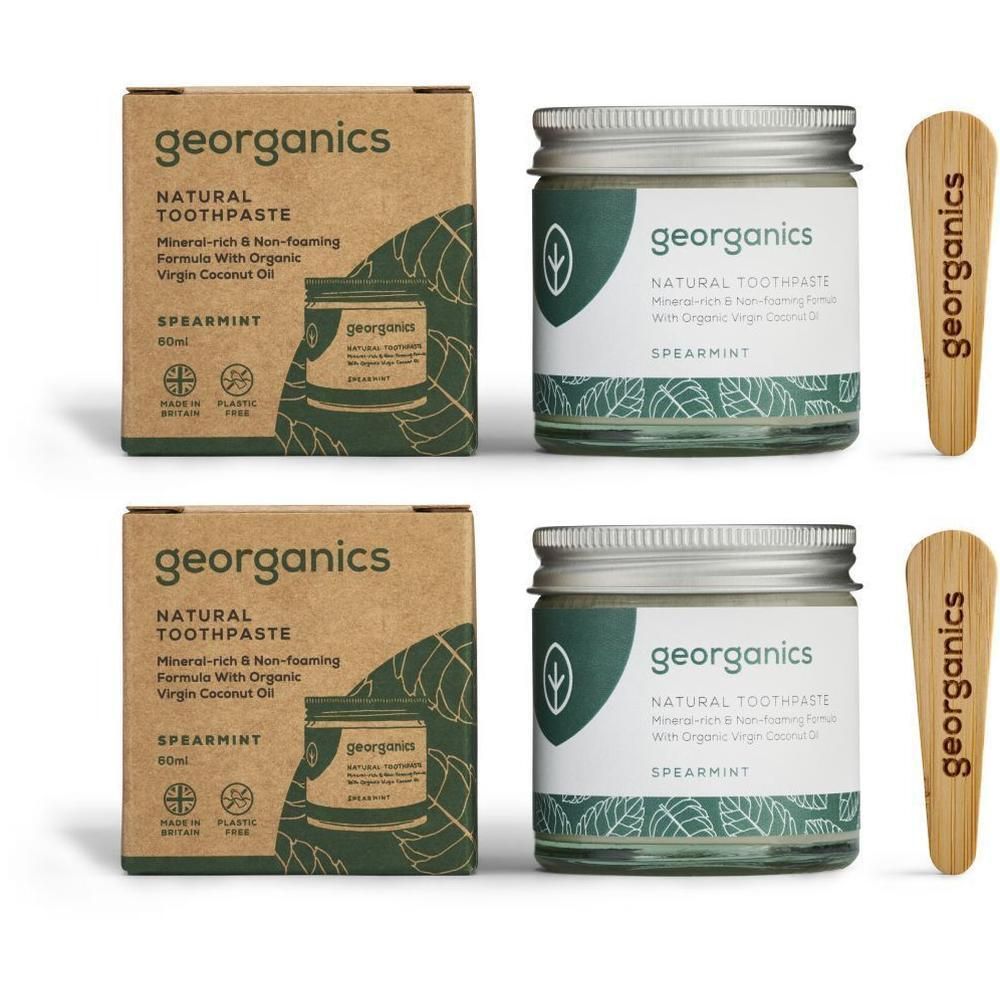 Zwei Gläser und zwei Kartons mit Zahnpasta. Aufschrift: georganics, Natural Toothpaste Spearmint. Zwei Holzspatel.