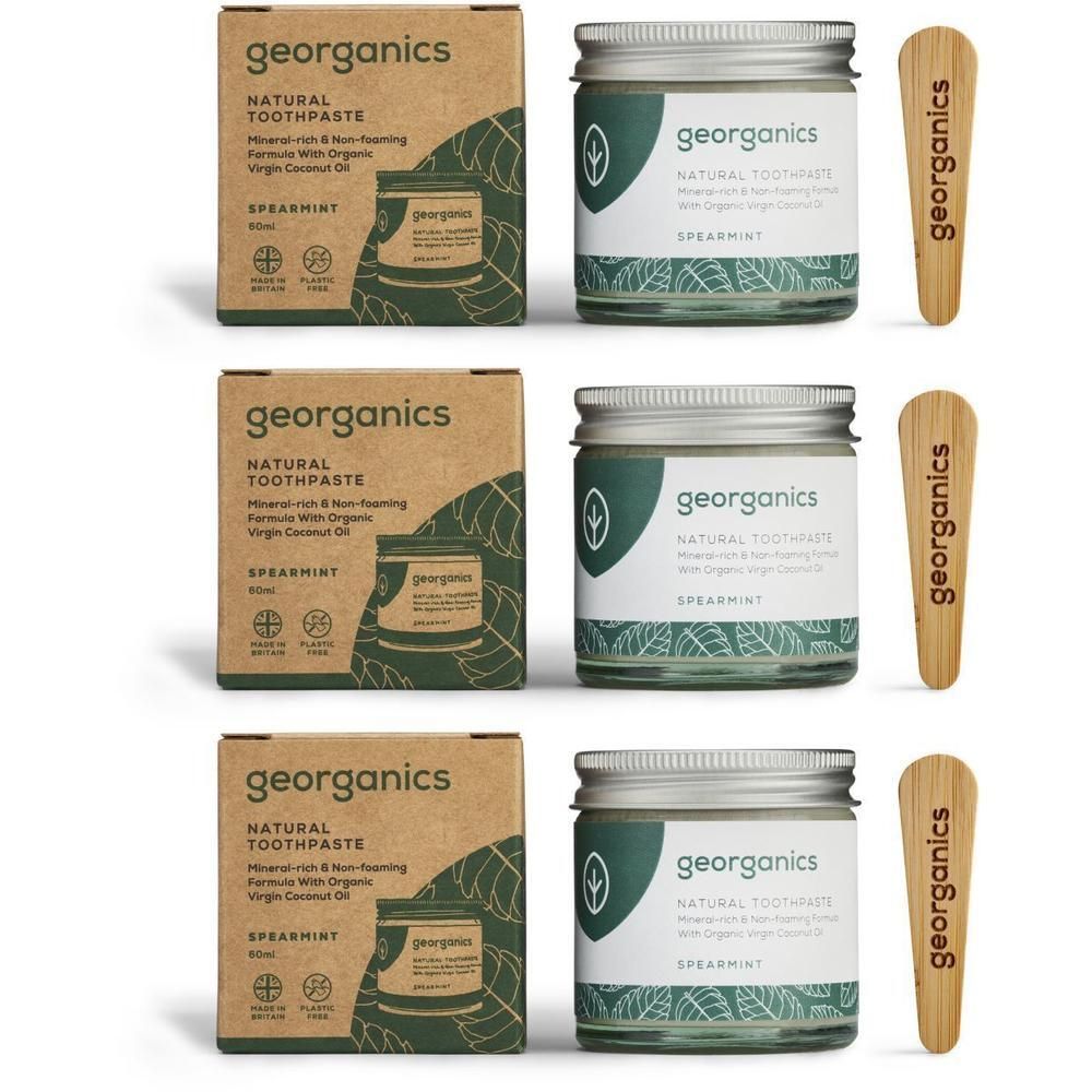 Drei Sets Zahnpasta. Jedes Set enthält eine Pappschachtel, ein Glas mit Zahnpasta und einen Holzspatel. Auf der Schachtel steht "georganics".