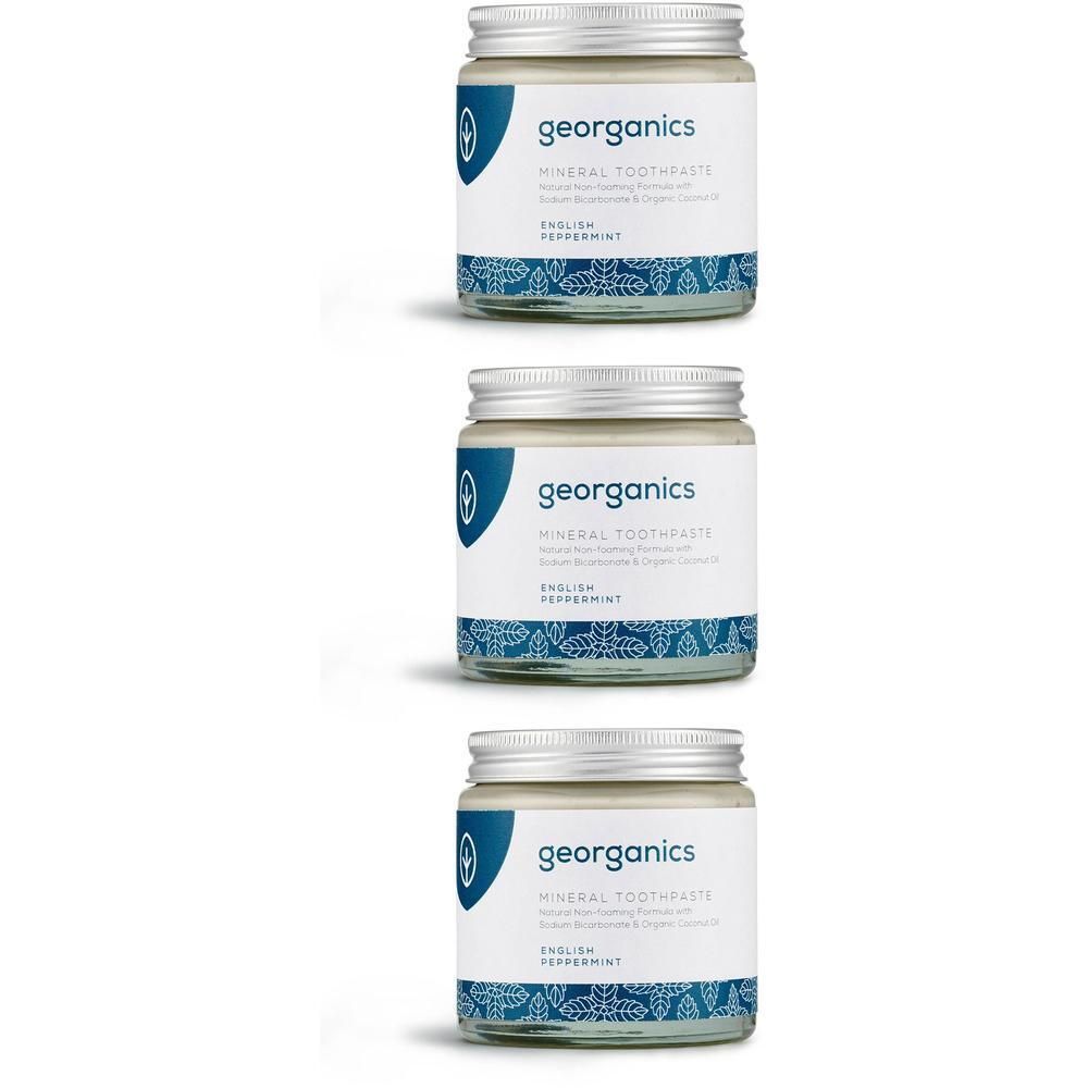 Drei Gläser Zahnpasta mit Schraubverschluss. Etikett mit Markenname und Produktbezeichnung. Blaues Muster am unteren Rand.