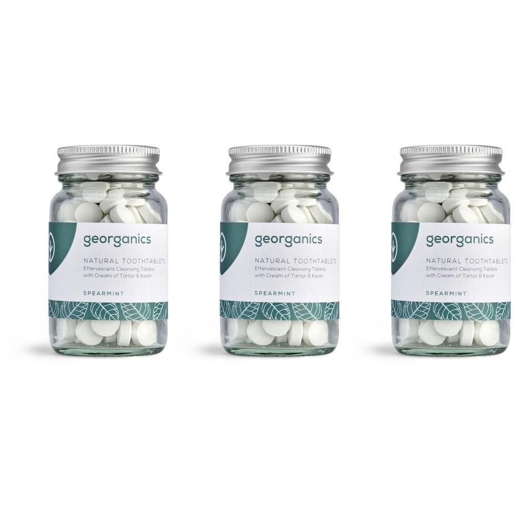 Drei Glasbehälter mit Tabletten. Auf Etiketten steht "georganics NATURAL TOOTH TABLETS Spearmint".