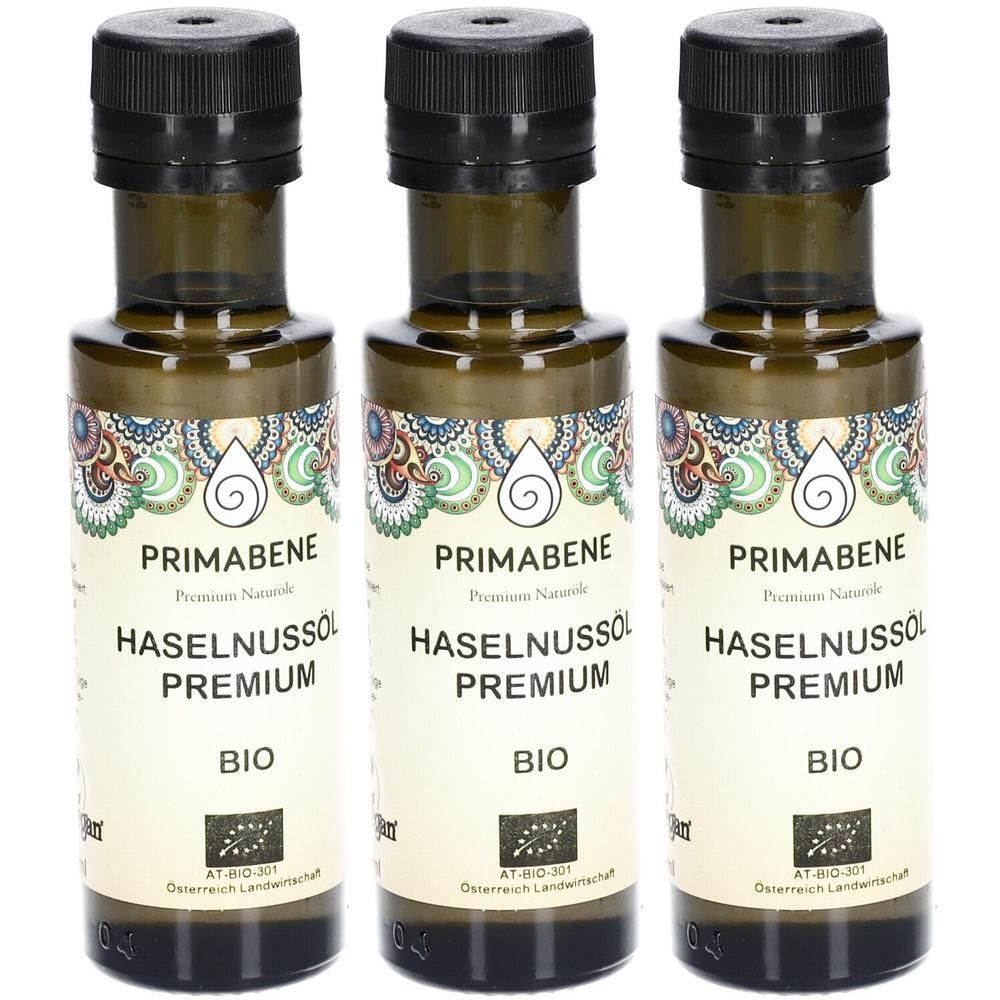 Drei Glasflaschen mit schwarzem Deckel. Etiketten mit Text: PRIMABENE, HASELNUSSÖL PREMIUM BIO. Bio-Siegel.
