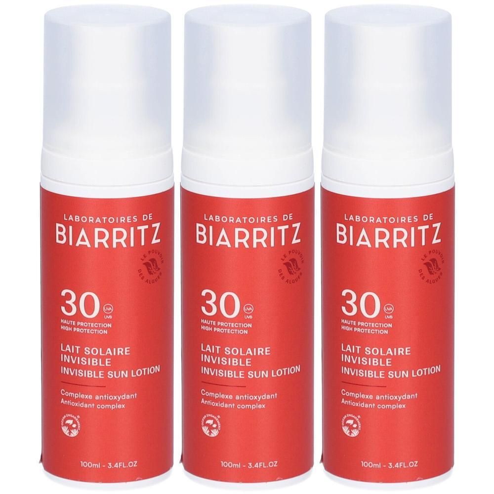 Drei Flaschen mit rotem Etikett und weißem Deckel. Aufschrift: Laboratoires de Biarritz, 30, Lait Solaire Invisible Sun Lotion.
