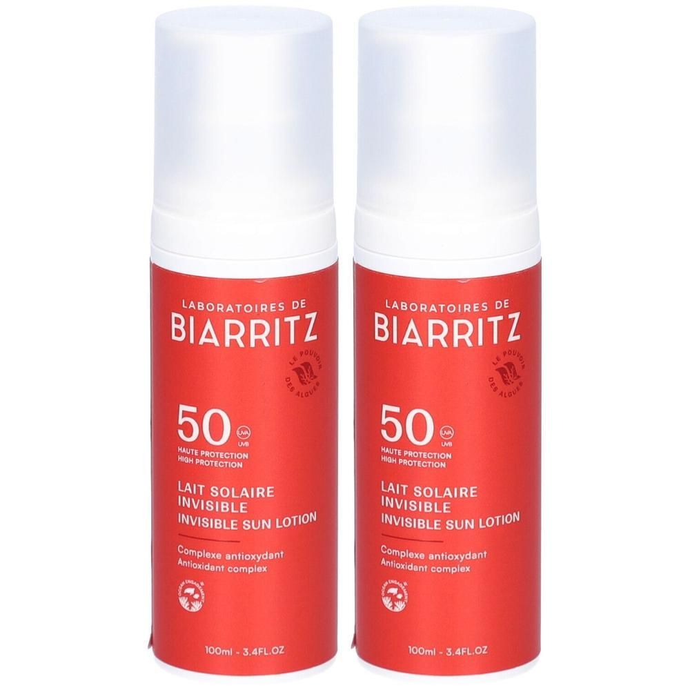 Zwei Flaschen Sonnenmilch. Rote zylindrische Flaschen mit weißem Deckel. Aufschrift: Laboratoires de Biarritz, 50, Lait Solaire Invisible.
