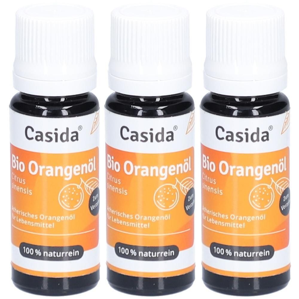 Drei Flaschen Casida Bio Orangenöl. Schwarze Flaschen mit weißen Deckeln. Orangefarbene Etiketten mit Produktinformationen und Schriftzug.