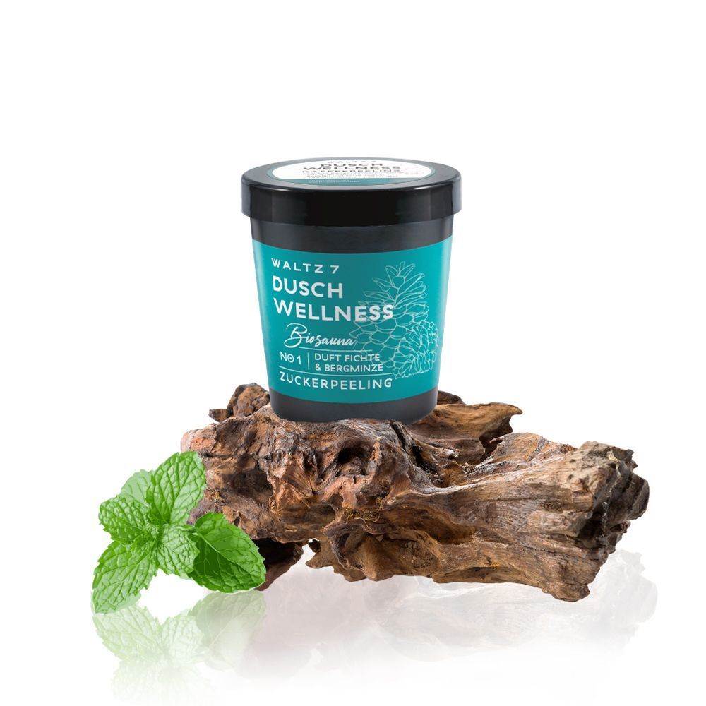 Ein Behälter WALTZ 7 Dusch Wellness Zuckerpeeling auf einem Stück Holz mit Minzblättern.