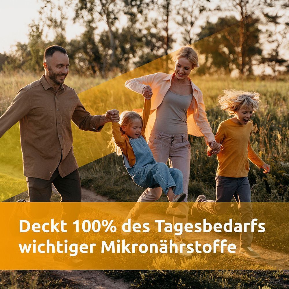 Eine Familie lachend im Freien, mit Text "Deckt 100% des Tagesbedarfs wichtiger Mikronährstoffe".