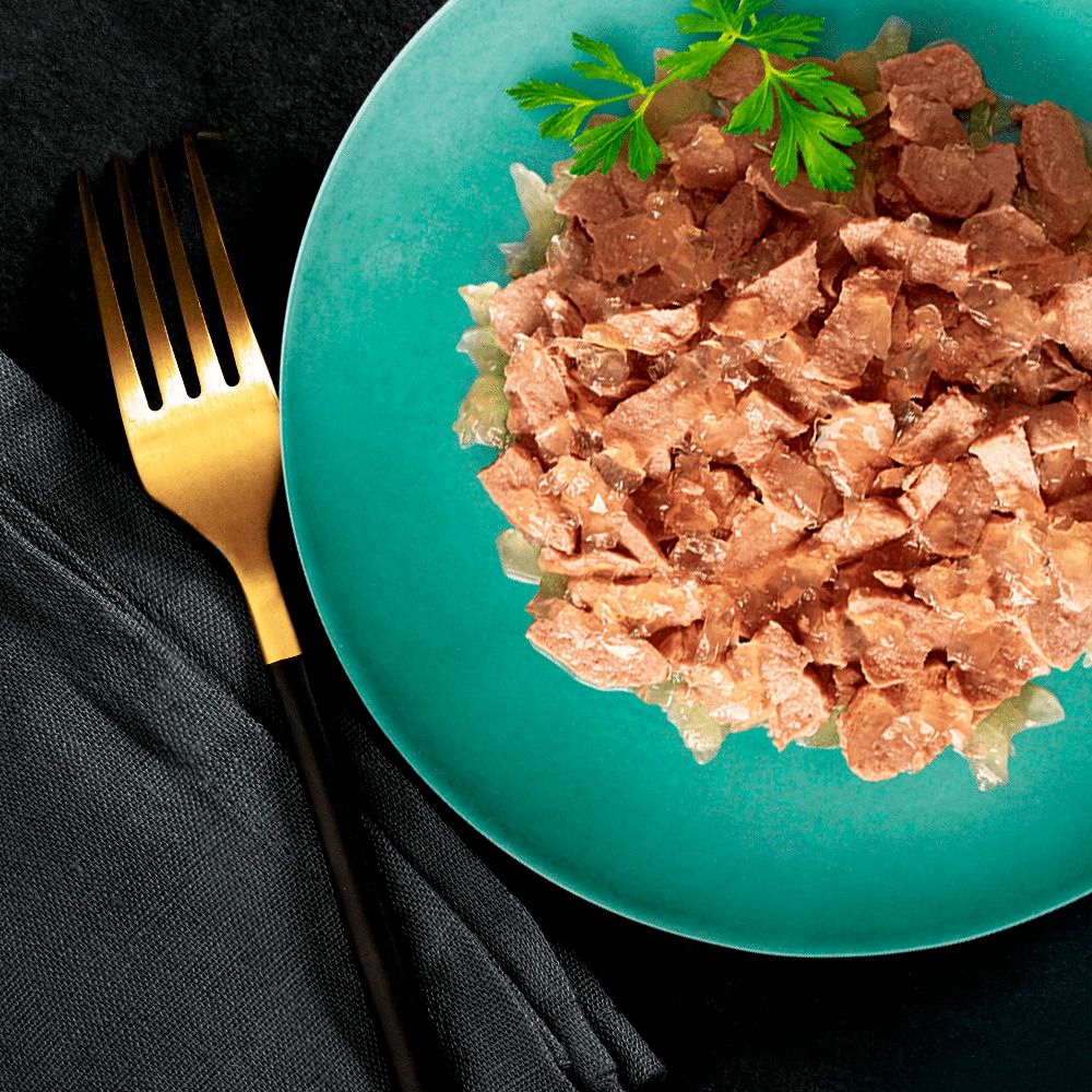 Eine Schale mit SHEBA Delikatesse Futter und einer goldenen Gabel.
