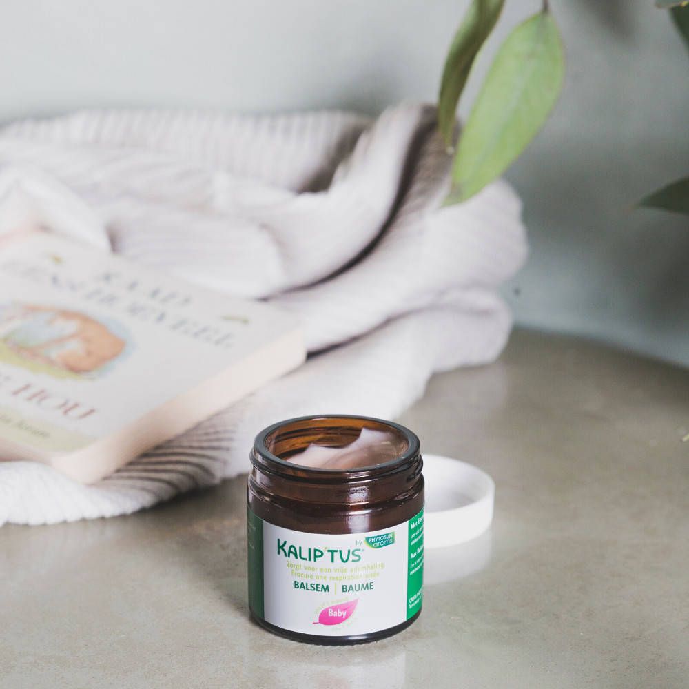 Geöffnete Dose mit Balsam. Aufschrift: Kalip'tus, Brustbalsam, Baby. Grün-weißer Aufkleber.
