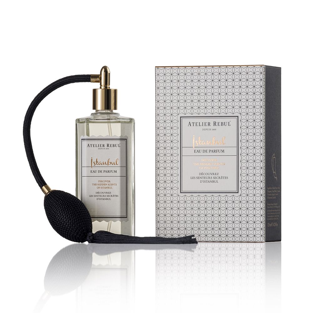 Eau de Parfum-Flakon mit Zerstäuber und Verpackung. Goldfarbener Zerstäuber, schwarzer Balg. Verpackung mit Muster.
