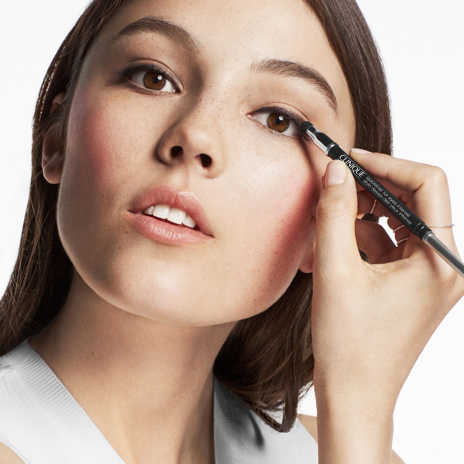 Frau trägt Eyeliner auf. Produkt ist sichtbar.