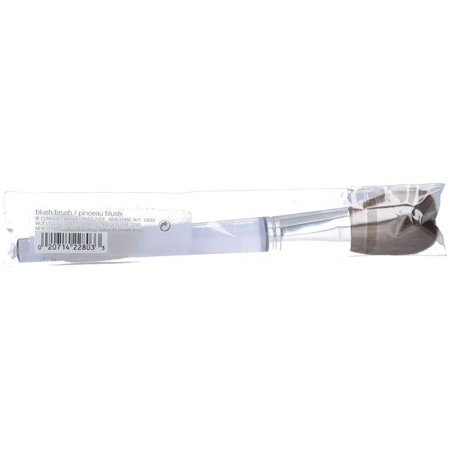 Pinsel in transparenter Verpackung. Silberfarbener Griff, braune Borsten. Aufschrift: blush brush / pinceau blush.