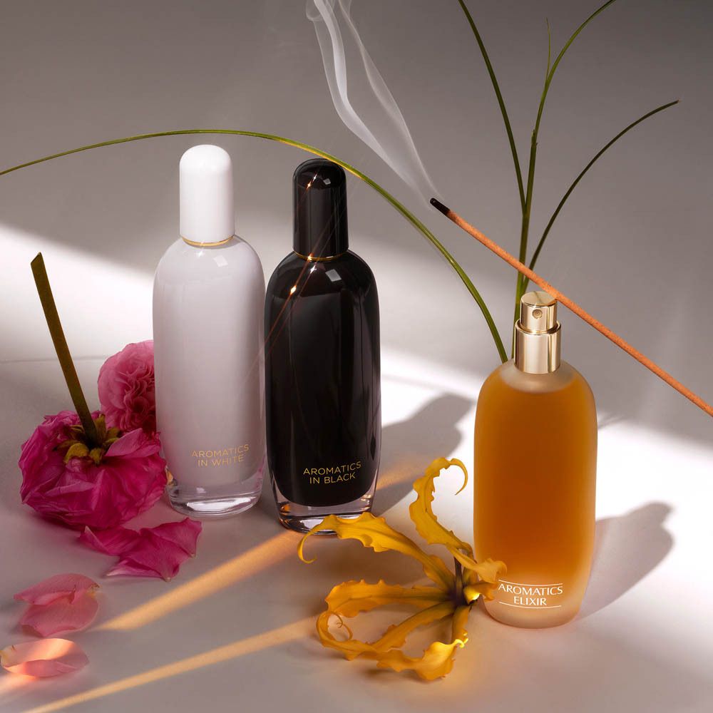 Drei Clinique Aromatics Elixir Parfümflaschen: weiß, schwarz und goldfarben.