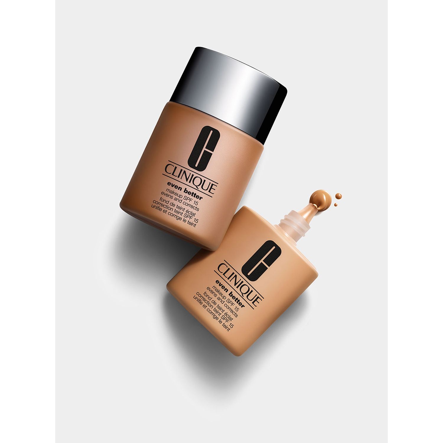 Zwei Flaschen Foundation. Eine geöffnet, eine geschlossen. Aufschrift: Clinique Even Better Glow SPF 15.