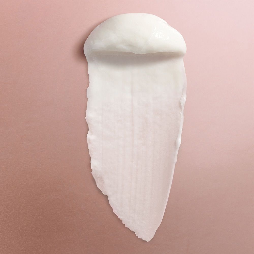 Weißes Produkt auf rosa Hintergrund. Creme-Textur, länglicher Abdruck.