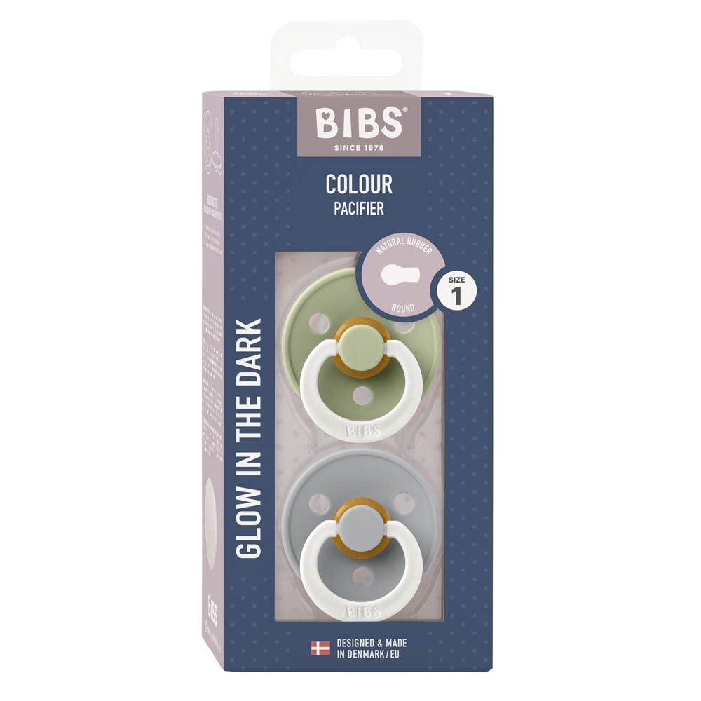 Verpackung mit zwei Schnullern. Blaue und grüne Schnuller mit weißem Ring. Text: BIBS, Colour, Glow in the Dark, 0+ Monate, Größe 1.