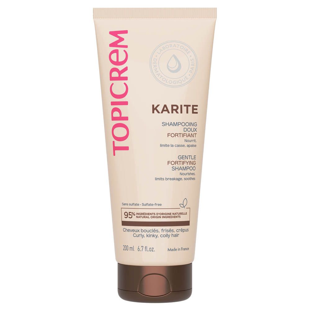 Beige Tube mit pinkfarbener Aufschrift TOPICREM. KARITE SHAMPOOING DOUX FORTIFIANT, GENTLE FORTIFYING SHAMPOO. Enthält 95% Inhaltsstoffe natürlichen Ursprungs. Für lockiges Haar.