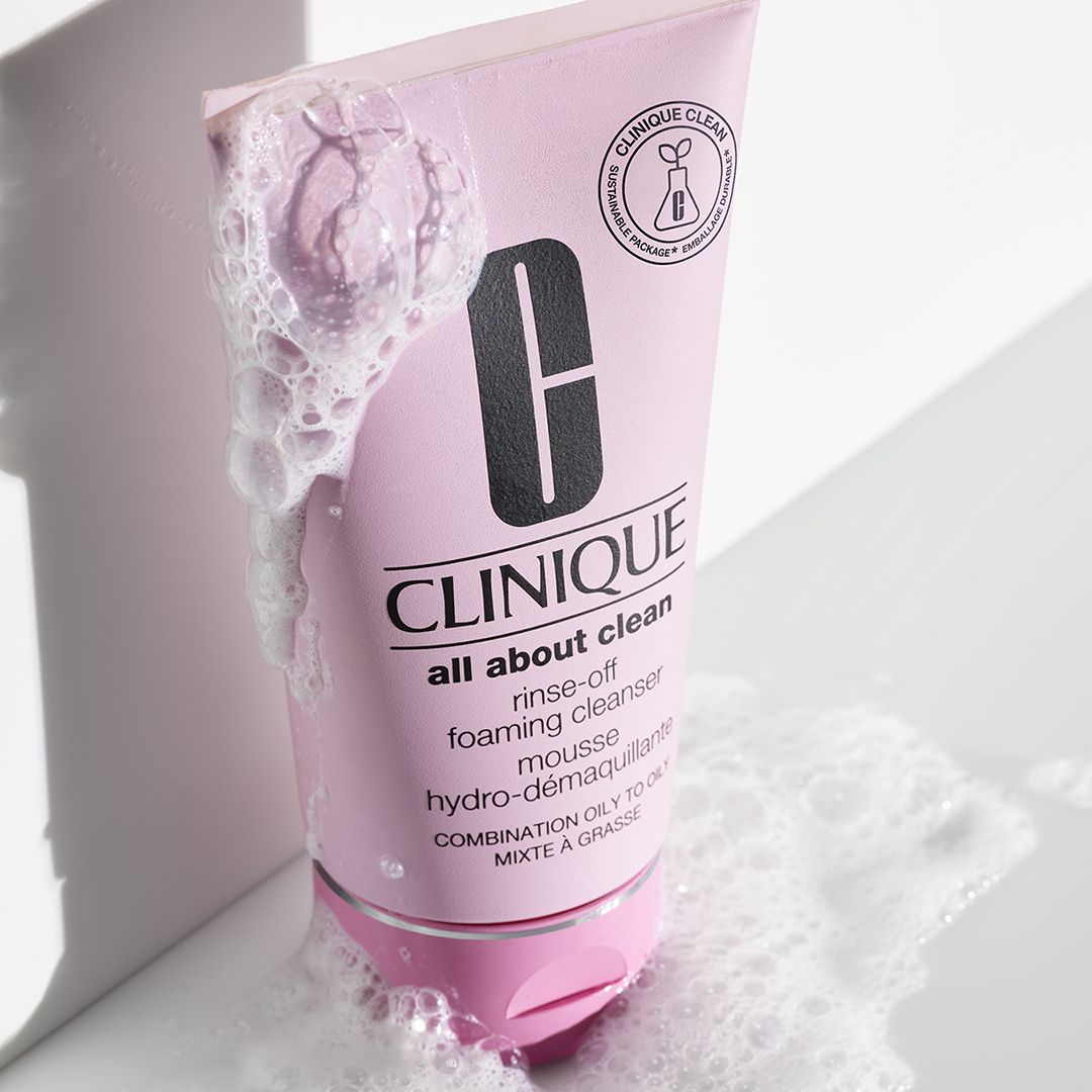 Rosa Tube mit Reinigungsschaum. Text: CLINIQUE all about clean. Schaum umgibt die Tube.