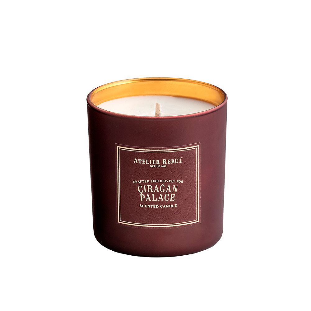 Braune Kerze mit goldenem Rand. Aufschrift: ATELIER REBUL, CIRAGAN PALACE, Duftkerze.