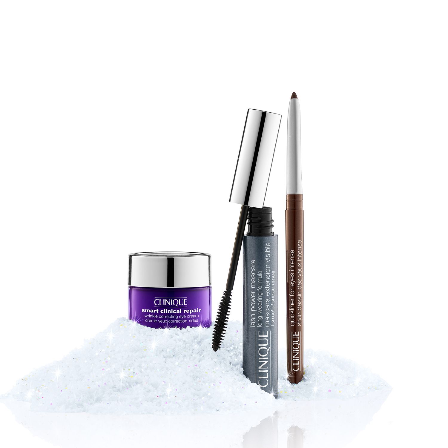 Augencreme, Mascara und Eyeliner. Produkte auf weißem Untergrund. Mascara-Bürste sichtbar. Eyeliner braun. Augencreme in lila Tiegel.