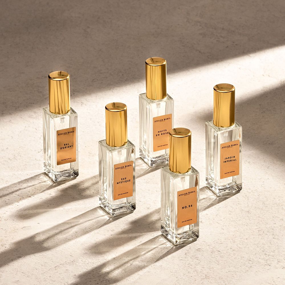 Fünf Atelier Rebul Eau de Parfum Flakons mit goldenen Verschlüssen, gruppiert auf einer strukturierten Oberfläche.