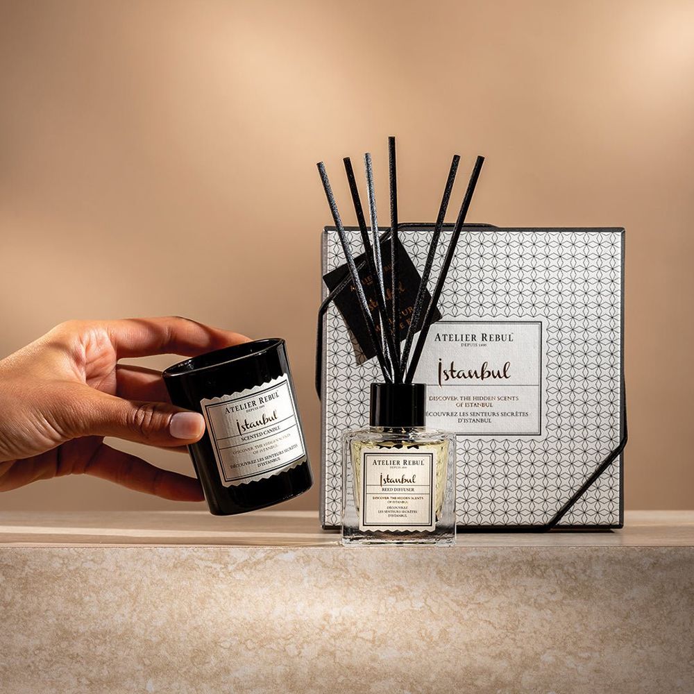 Hand hält Kerze. Kerze, Diffusor und Box. Kerze und Diffusor mit Etiketten. Box mit Muster und Etikett.