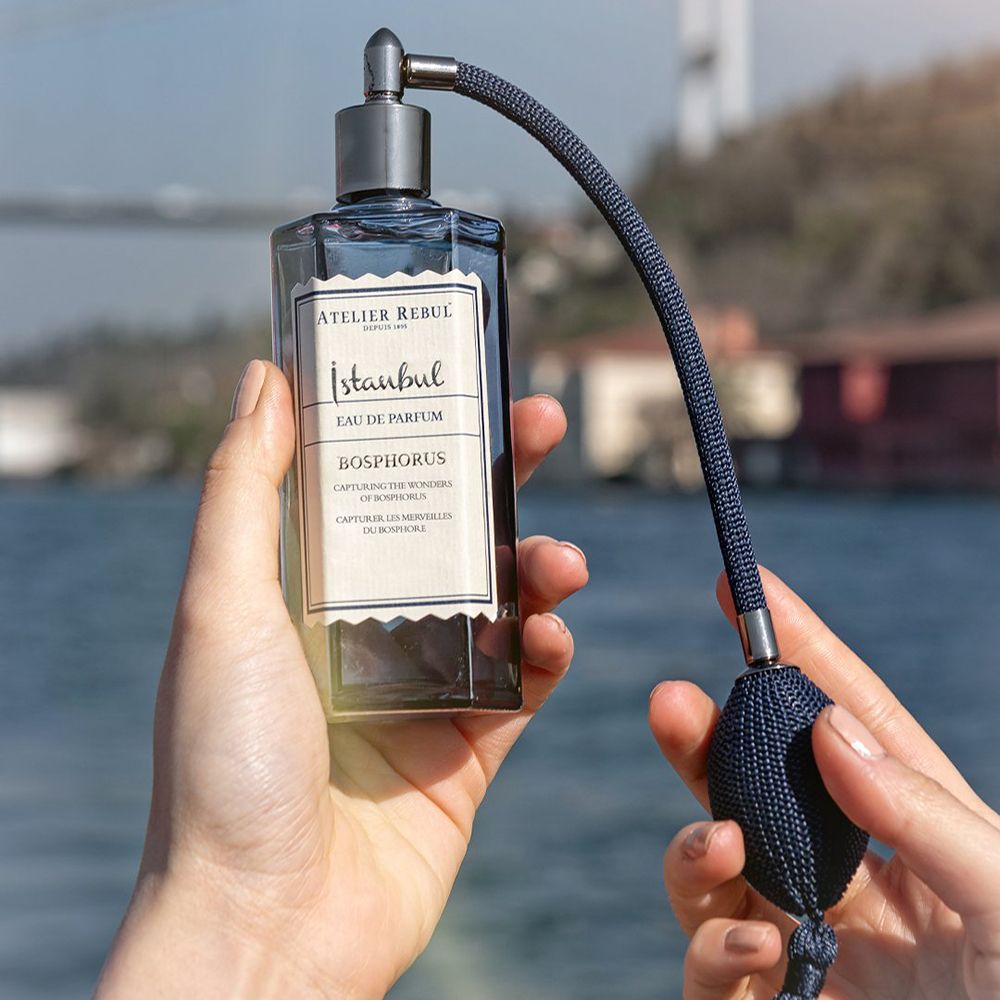 Dunkelblaue Flasche mit Zerstäuber und Quaste. Aufschrift: Istanbul Bosphorus Eau De Parfum. In Händen gehalten.