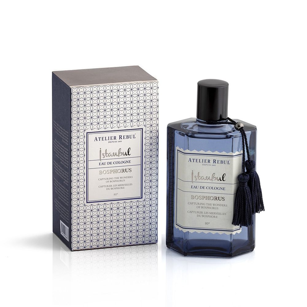 Blaues Eau de Cologne mit schwarzem Verschluss und Quaste. Rechteckige Flasche und Schachtel mit Muster und Etikett.