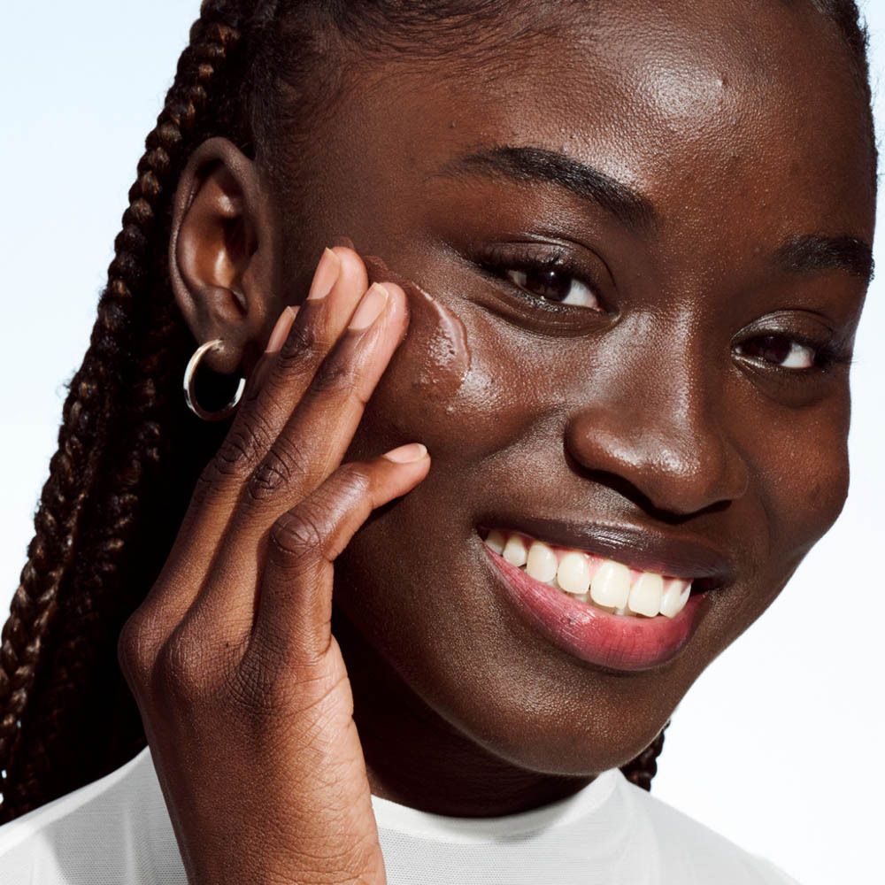Person trägt Clinique Even Better Clinical Vitamin Makeup auf. Nahaufnahme.
