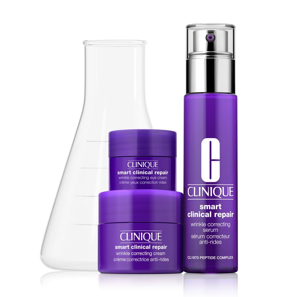 Clinique Smart Clinical Repair Set. Lila Serum, Creme und Augencreme. Neben einem Erlenmeyerkolben. Enthält Anti-Aging-Produkte.