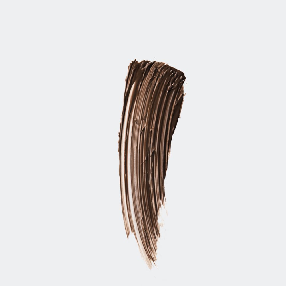 Braunes Brauen-Gel auf weißem Hintergrund. Textur mit Pinselstrichen.