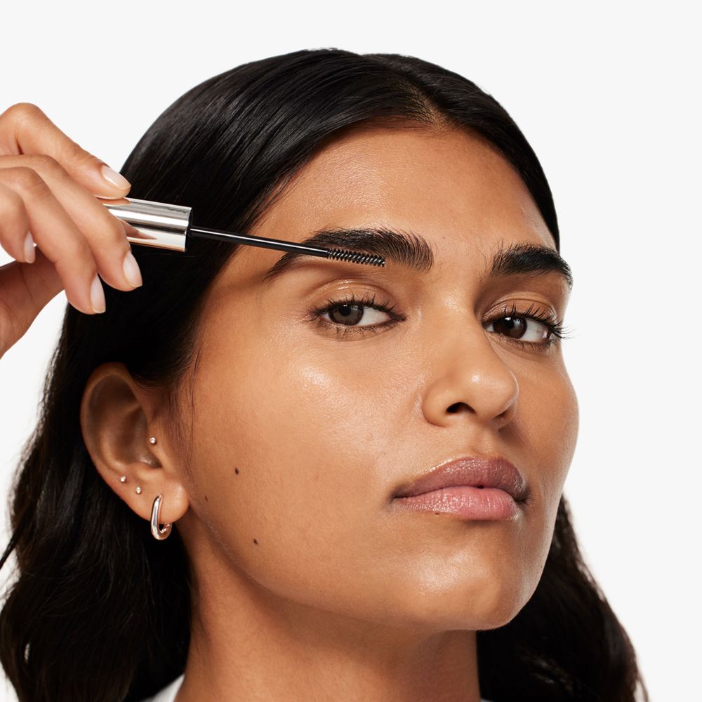 Frau mit Augenbrauen-Gel. Gel wird mit Bürste aufgetragen. Produkt nicht sichtbar.