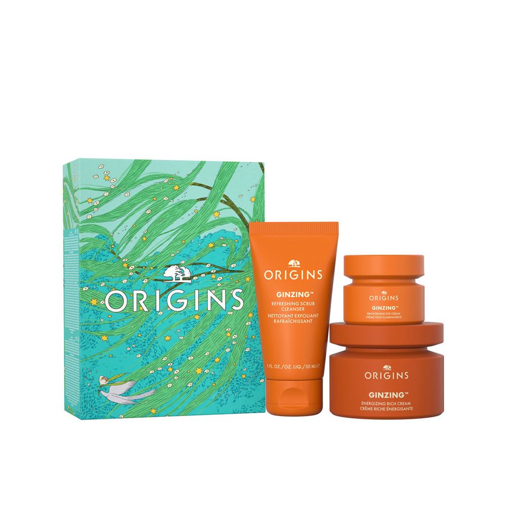 Geschenkset mit drei orangefarbenen Tiegeln und einer Tube. Die Verpackung zeigt das Logo von Origins.