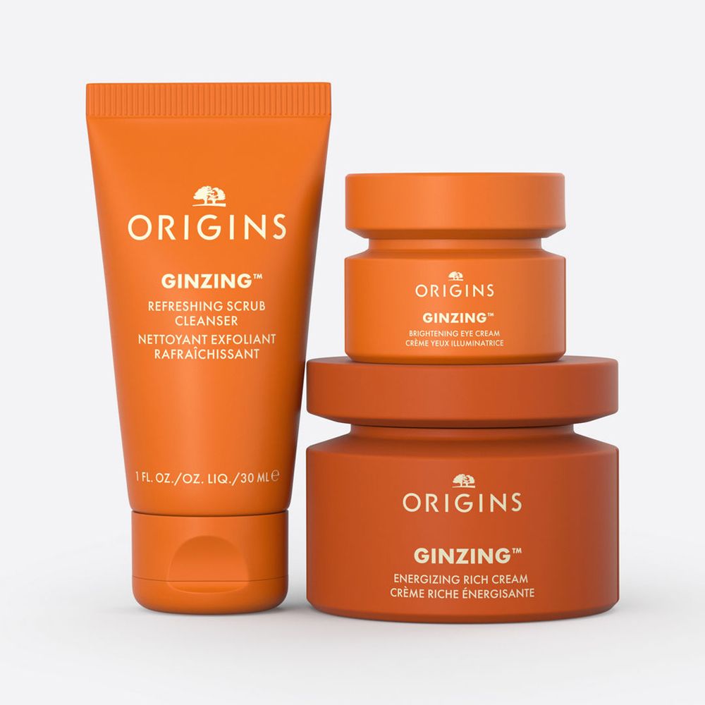 Drei orangefarbene Tiegel und eine Tube. Auf den Produkten steht der Name Origins und Ginzing.