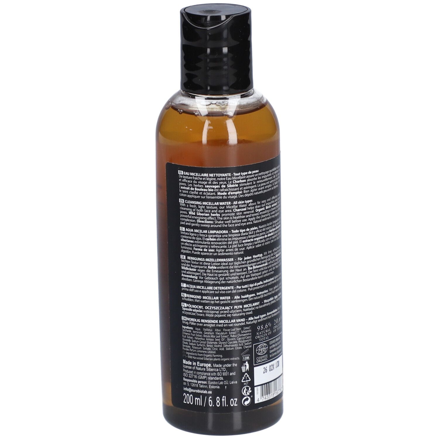 Rückansicht der Flasche. Schwarzes Etikett mit Text. Informationen über Inhaltsstoffe und Hersteller. Transparente Flasche mit brauner Flüssigkeit. Schwarzer Deckel.