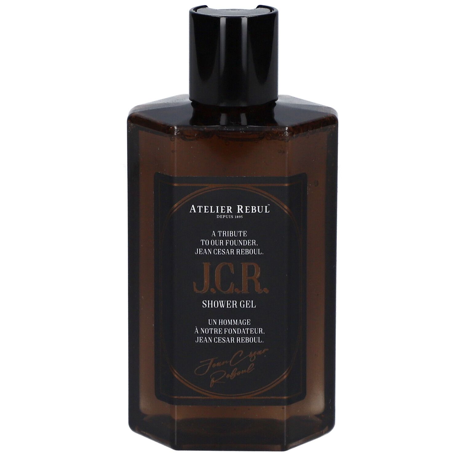 Braune, sechseckige Flasche mit schwarzem Deckel. Etikett mit Text: Atelier Rebul J.C.R. Shower Gel.
