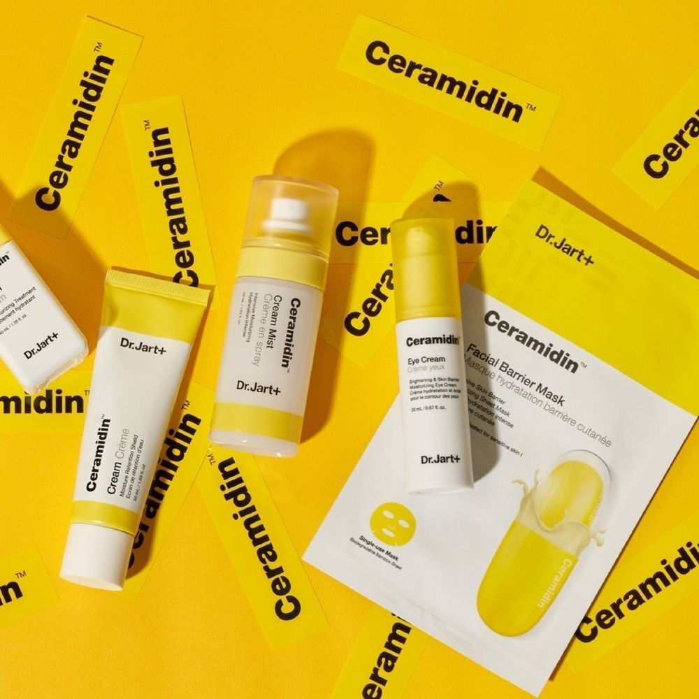 Gelber Hintergrund mit verschiedenen Dr.Jart+ Ceramidin Produkten. Enthalten: Maske, Creme, Serum, Nebel und Aufkleber.