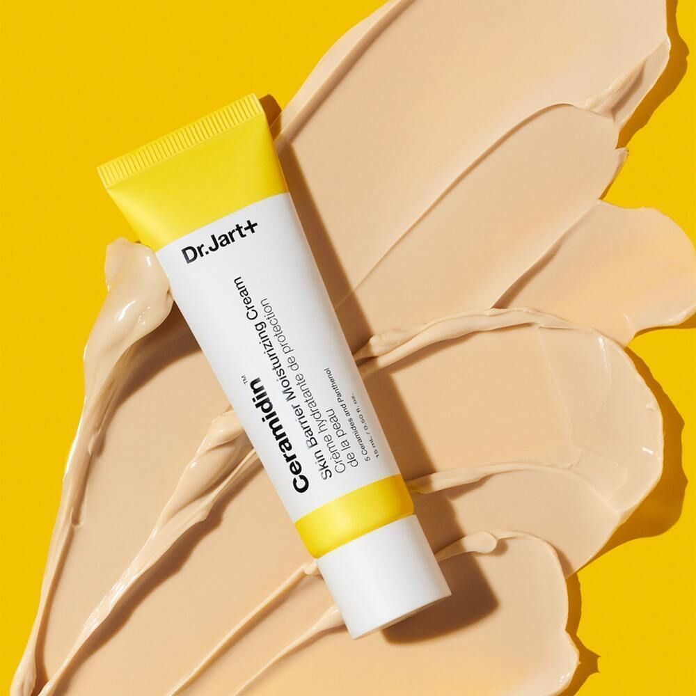 Tube Dr.Jart+ Ceramidin Skin Barrier Moisturizing Cream auf gelbem Hintergrund. Creme-Textur im Vordergrund.