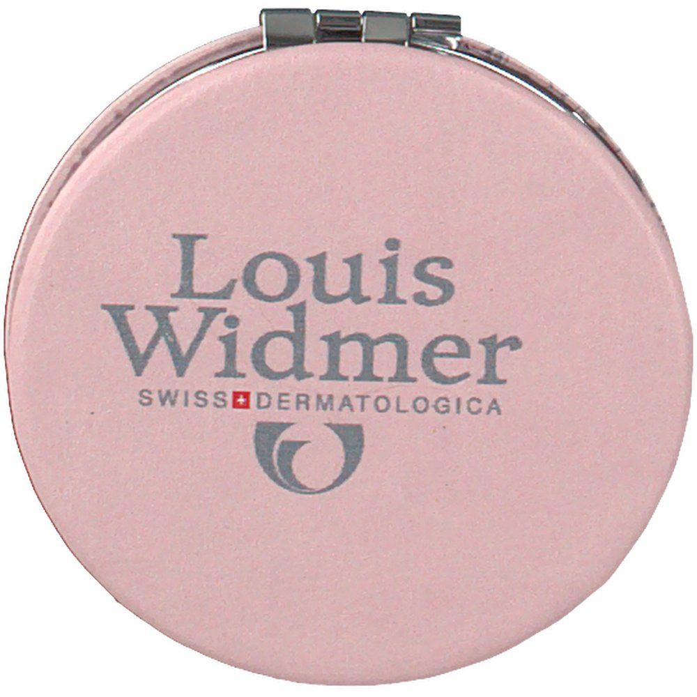 Runder, rosa Kosmetikspiegel. Aufschrift: Louis Widmer, Swiss Dermatologica. Silberfarbener Scharnierverschluss.