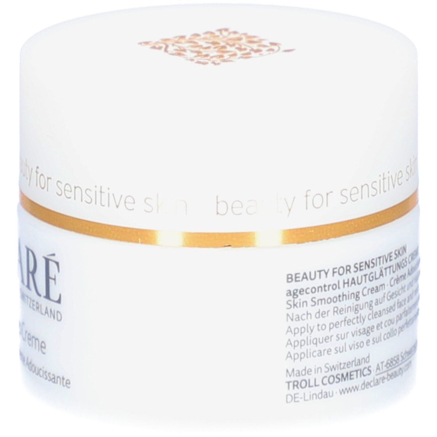 Weißer Creme-Tiegel mit goldfarbenem Rand. Aufschrift: DECLARÉ, Hautglättungs Creme. Text: Skin Smoothing Cream, Crème Adoucissante.