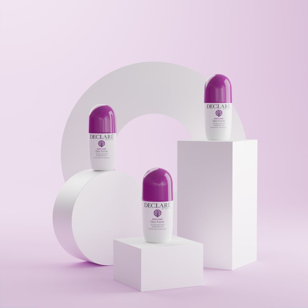 Drei Deo Forte Roll-ons auf weißen Podesten. Hintergrund: weiße und rosa Formen. Lila Kappen sichtbar.