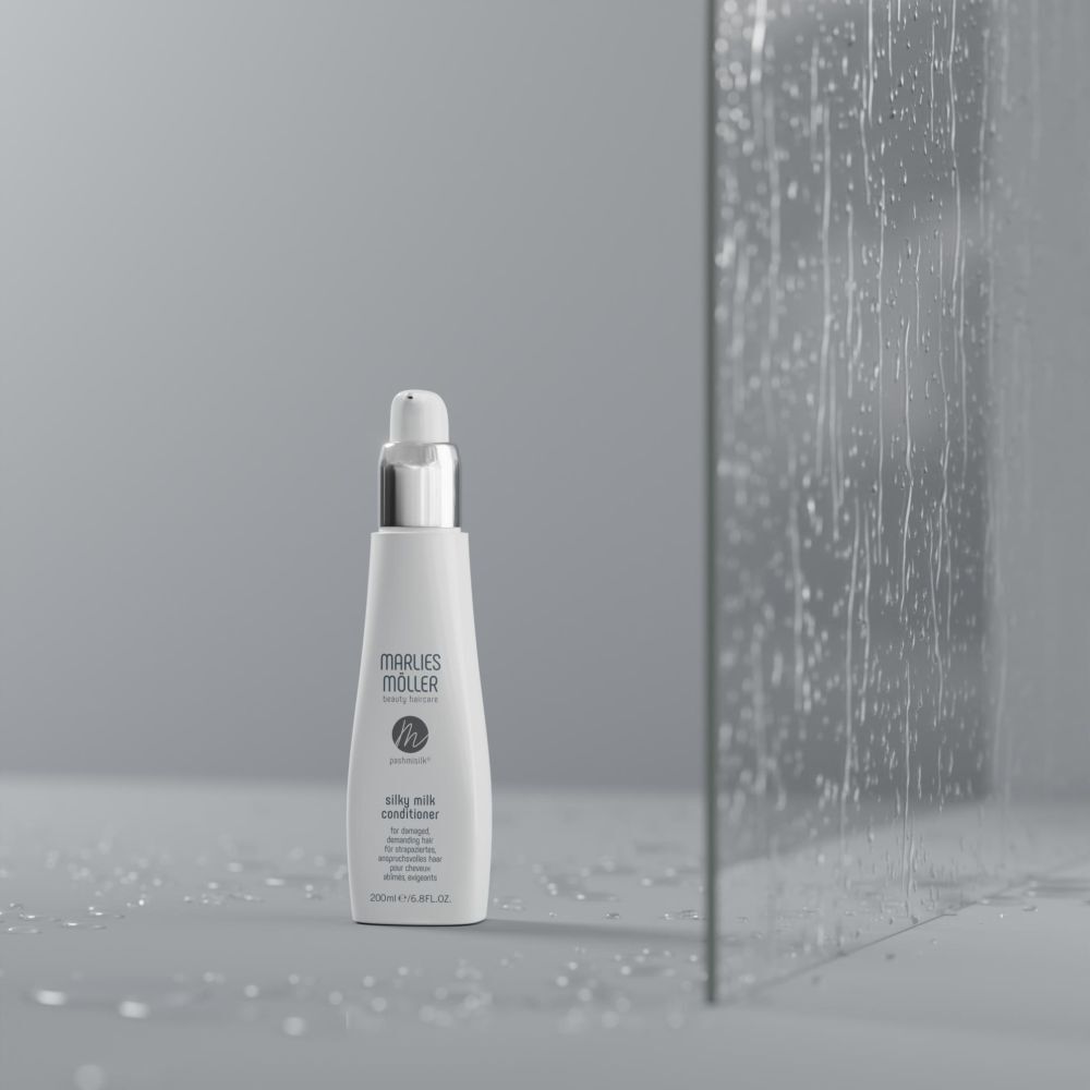 Produktflasche vor Glaswand. Flasche: weiß, silberner Verschluss. Aufschrift: Marlies Möller, Silky Milk Conditioner.
