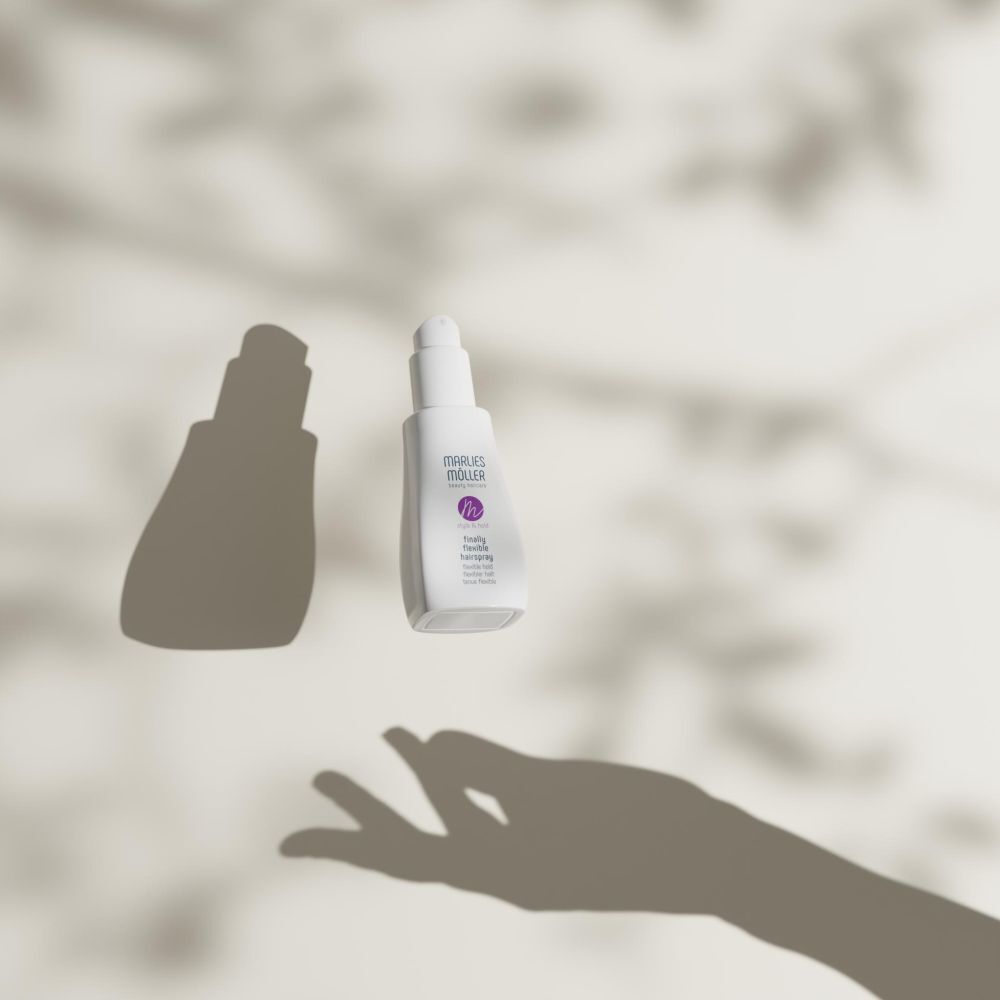 Schattensilhouette einer Hand und einer Flasche mit Sprühkopf. Aufschrift: Marlies Möller, Style & Hold.