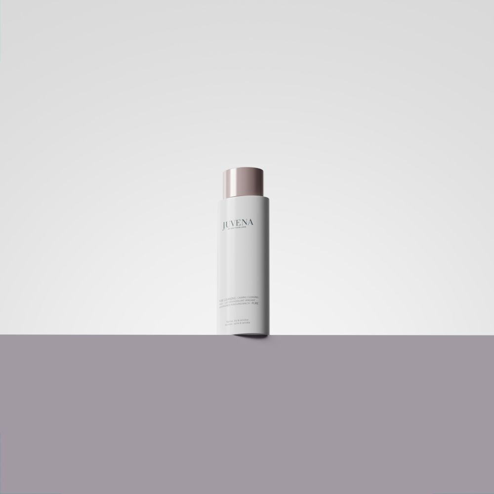 Weisse Flasche mit rosafarbenem Deckel. Juvena-Logo. Auf weißem und grauem Hintergrund.