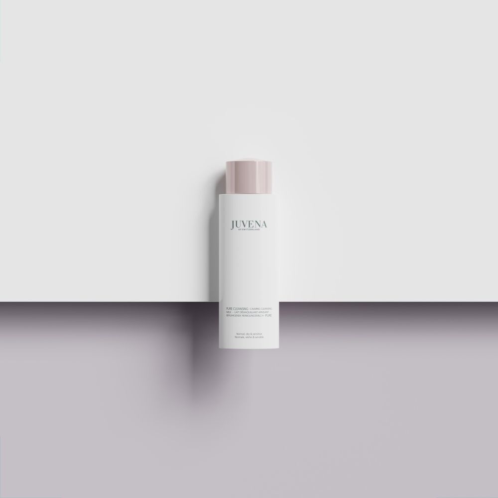 Weisse Flasche mit rosafarbenem Deckel. Juvena-Logo. Auf weißem und grauem Hintergrund.