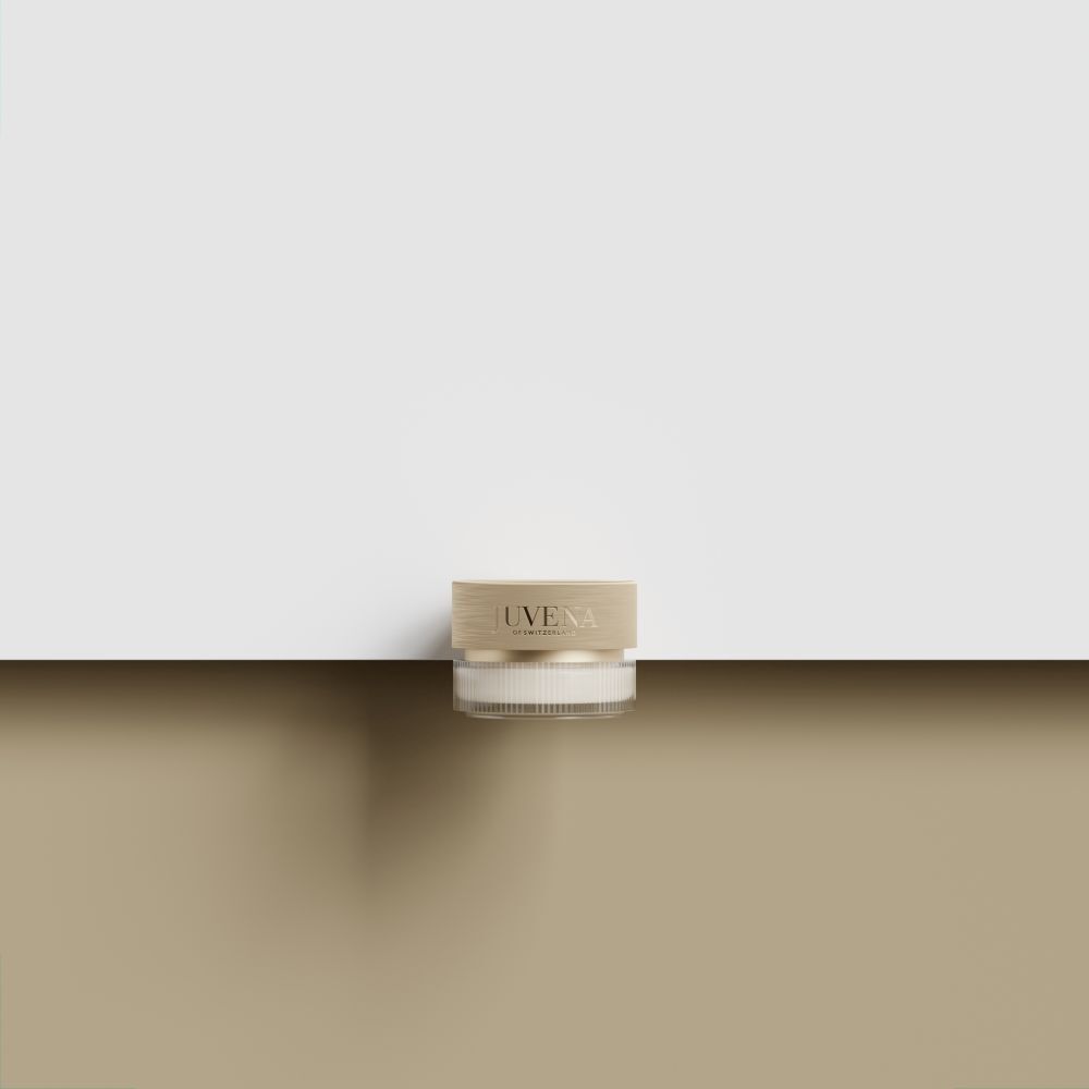 Creme-Glas mit goldfarbenem Deckel. Aufschrift: JUVENA. Auf braunem und weißem Hintergrund.