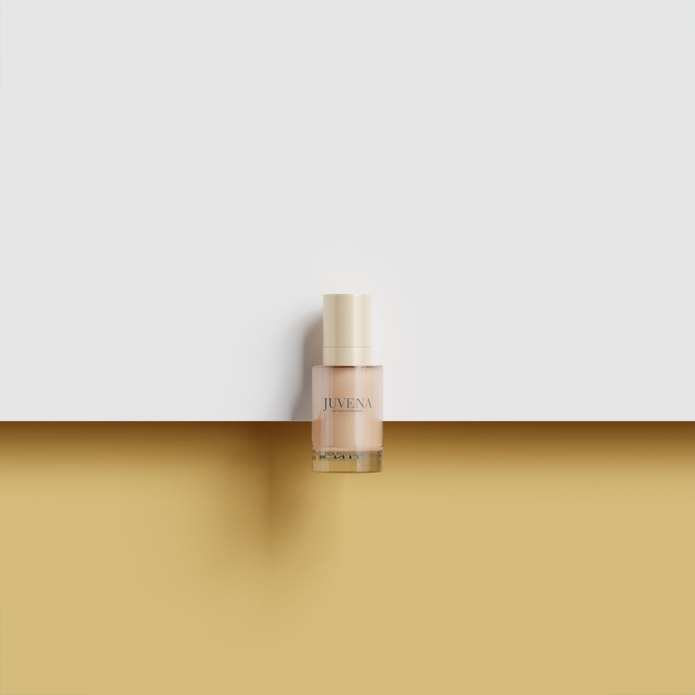 Flüssigkeit in einer Glasflasche mit goldenem Deckel. Auf goldenem und weißem Hintergrund.