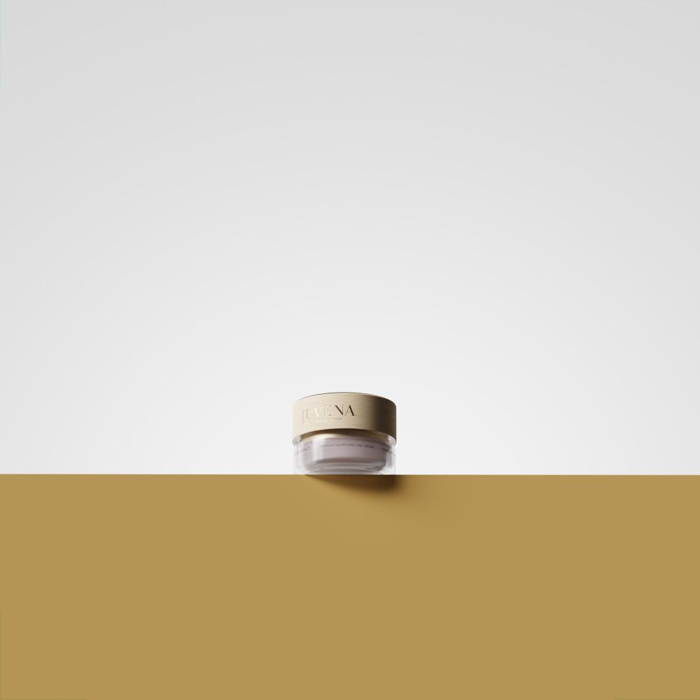 Crème-Glas mit goldfarbenem Deckel. Aufschrift: JUVENA. Auf goldfarbenem Untergrund platziert.