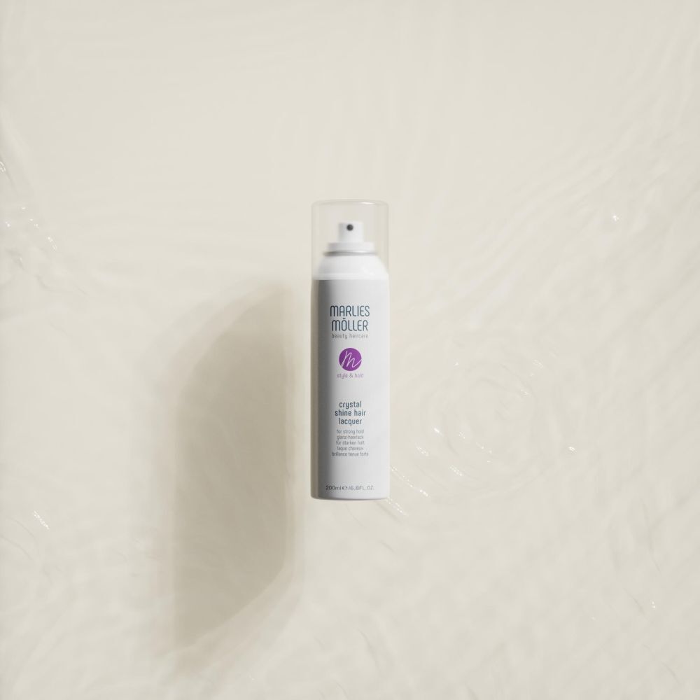 Weißes Haarspray von Marlies Möller. Produkt liegt in Wasser. Aufschrift: Crystal Shine Hair Lacquer.